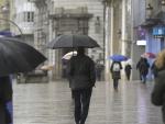 Varias personas caminan bajo la lluvia en A Coruña.