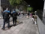 Santiago de Compostela. Un joven recoge dos bolsas del suelo mientras es desalojado por la policia Local en las inmediaciones de la discoteca Ruta