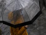 Una persona pasea en un d&iacute;a de lluvia protegi&eacute;ndose con un paraguas.