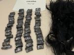 Envoltorios de cocaína junto a la peluca en la que llevaba escondida la droga la mujer detenida el pasado lunes en Barcelona.