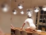 Una mujer rompe una lámpara con la cabeza al bailar sobre una mesa.