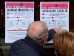 Dos personas observan un cartel con las pautas para recibir la tercera dosis de Pfizer en Valladolid.