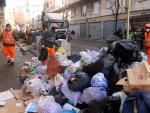 Trabajadores recogiendo este miércoles los residuos acumulados en la calle Torras i Bages de Salt (Girona) en el quinto día de huelga del servicio.