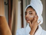 Mujer aplicando crema facial en su rostro.