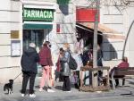 Varias personas guardan cola ante una farmacia del barrio del Guinard&oacute;, en Barcelona, que vende y realiza test de ant&iacute;genos.