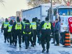 Agentes policiales pasan junto a la zona donde se concentran las protestas de los grupos antivacunas, frente al Parlamento de Canad&aacute;, en Ottawa.