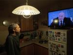 Una mujer observa desde su casa en San Petersburgo un discurso de Vlad&iacute;mir Putin.