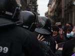 Antidisturbios de los Mossos intervienen para separar a dos grupos de manifestantes feministas este 8-M en Barcelona.