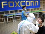 Un trabajador m&eacute;dico realizando una prueba de COVID en una f&aacute;brica de Foxconn en Wuhan en agosto de 2021.