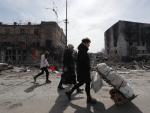 Varias personas caminan junto a edificios destruidos por los bombardeos en Mari&uacute;pol, Ucrania, el 10 de abril de 2022.