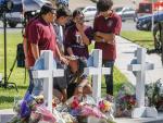 Familiares dejan flores en cruces en recuerdo a las v&iacute;ctimas de la matanza escolar de Texas.