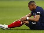 Mbapp&eacute; se lleva la mano a la pierna durante el partido de Francia.