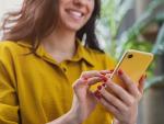 Cropped image of happy girl using smartphone device while chilling at hom