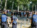 Varios polic&iacute;as controlan la multitud de estudiantes tras finalizar las pruebas de la EvAU en Madrid.