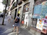 Dos mujeres pasan por delante de los locales comerciales del n&uacute;mero 17 de la calle de Valencia, en Madrid.