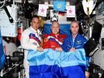 Los cosmonautas rusos Oleg Artemyev, Denis Matveev y Sergey Korsako posan con la bandera de la autoproclamada Rep&uacute;blica Popular de Luhansk en la Estaci&oacute;n Espacial Internacional.