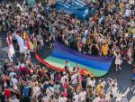 Centenares de personas rodean la bandera LGTBI a su paso por la Cibeles durante la manifestaci&oacute;n del Orgullo LGTBIQ+ en Madrid este s&aacute;bado.