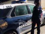 Imagen de archivo de un agente de la Polic&iacute;a Nacional junto a su coche patrulla.