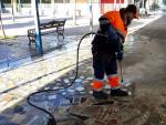 Un trabajador de Lipasam limpia los soportales de Juan XIII con agua a presi&oacute;n.