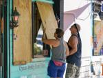 Dos residents protegen las ventanas de una tienda en Gulfport, Florida (EE UU), ante la llegada del hurac&aacute;n Ian.