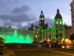 La fuente de la plaza del Ayuntamiento de Valencia se ilumina de verde.