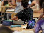 Foto de archivo de un alumno con una tablet en clase.