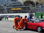 Varios operarios empujan el coche de Alonso