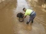 Un operario en un paso inundado en Xirivella tras las fuertes lluvias de este s&aacute;bado.
