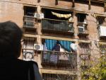 Una persona observa la terraza y las ventanas de la vivienda incendiada, ubicada en el barrio de las Moreras de C&oacute;rdoba.