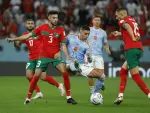 Noussair Mazraoui (i) y Selim Amallah (d) de Marruecos disputan un balón con Ferrán Torres de España