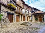Plaza del pueblo con antiguas casas tradicionales y cruz de piedra, Mogarraz Salamanca