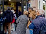 Personas haciendo cola en la famosa administraci&oacute;n de loter&iacute;a de Sevilla El Gato Negro, donde se ha vendido el Gordo.