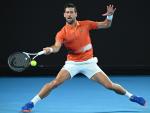 Novak Djokovic golpea un 'drive' en un partido de entrenamiento ante Nick Kyrgios en Melbourne.