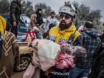Un miembro de los Cascos Blancos de Siria traslada en brazos a un ni&ntilde;a que ha sido recuperada con vida bajo los escombros de un edificio derrumbado por el terremoto en la ciudad de Harem.