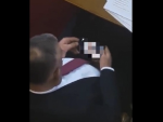 El diputado serbio viendo pornografía en su móvil.