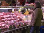 Una mujer observa los precios en el mostrador de una carnicer&iacute;a en Madrid.