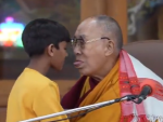 El Dalai Lama saca la lengua a un ni&ntilde;o al que acaba de besar en la boca durante un acto p&uacute;blico, en abril de 2023