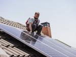 Un t&eacute;cnico instala paneles solares en un tejado.