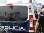 Imagen de archivo de un agente y un furgón de la Policía Nacional.