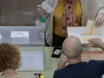 Una mujer deposita sus votos en las urnas habilitadas en un colegio electoral de Valencia para las elecciones municipales y auton&oacute;micas.