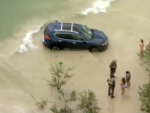 Mujer conduce coche por una playa Florida