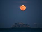 La luna llena se eleva sobre la isla de Alcatraz en San Francisco, California.