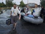 Ciudadanos ucranianos siendo evacuados de un vecindario inundado en Jers&oacute;n.