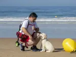 El cuidador y preparador canino, Juan Luis de Castellví, junto a Chui, en la playa de La Barrosa en Chiclana de la Frontera.