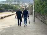Una pareja pasea por un paseo mar&iacute;timo en Bizkaia pertrechados de paraguas.