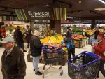 Compradores hacen cola y observan productos en un supermercado de Barcelona.