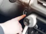Imagen de un conductor apretando el botón para apagar el motor de su coche