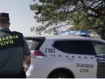 Imagen de archivo de un agente y un coche de la Guardia Civil.