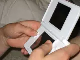 Una chica jugando a la Nintendo DS Lite.