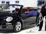 Un trabajador de Volkswagen abrillanta un New Beetle descapotable con los asientos de cuero.